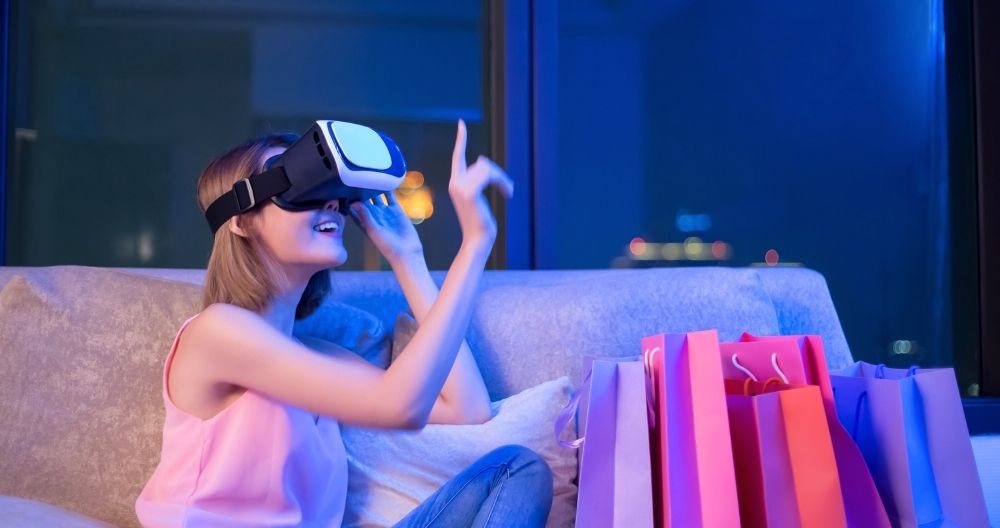A girl wearing a VR headset, immersed in a virtual experience, sitting on a sofa with shopping bags nearby.