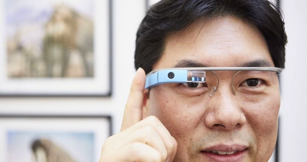 A man wearing Google Glass Enterprise Edition 2 and putting finger on the side of the Glass.