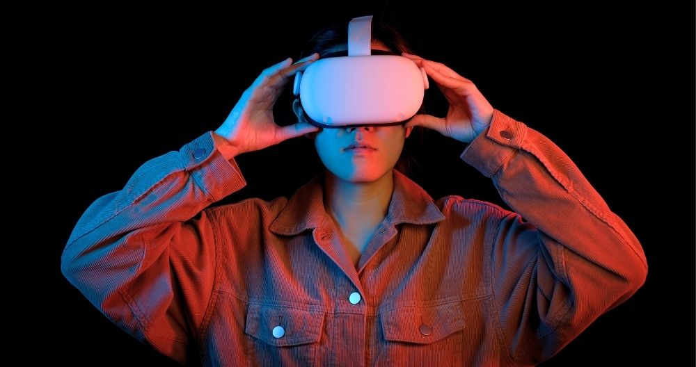 A woman Wearing VR headset and putting hands on her headset. The background is black.